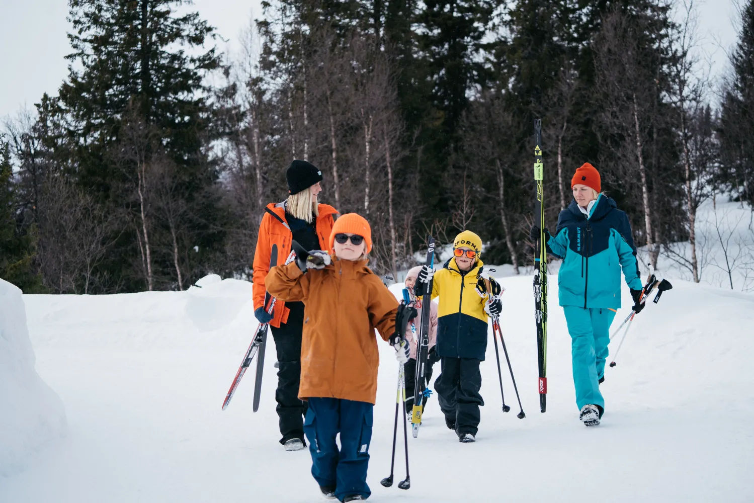 Familj som går med skidor i snön