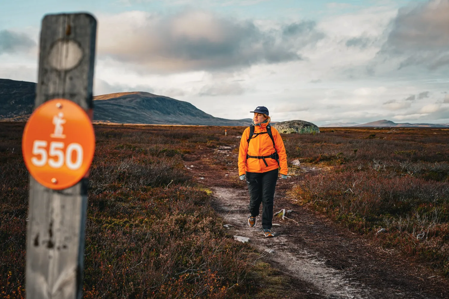 En tjej som vandrar längst med en vandringsled under hösten