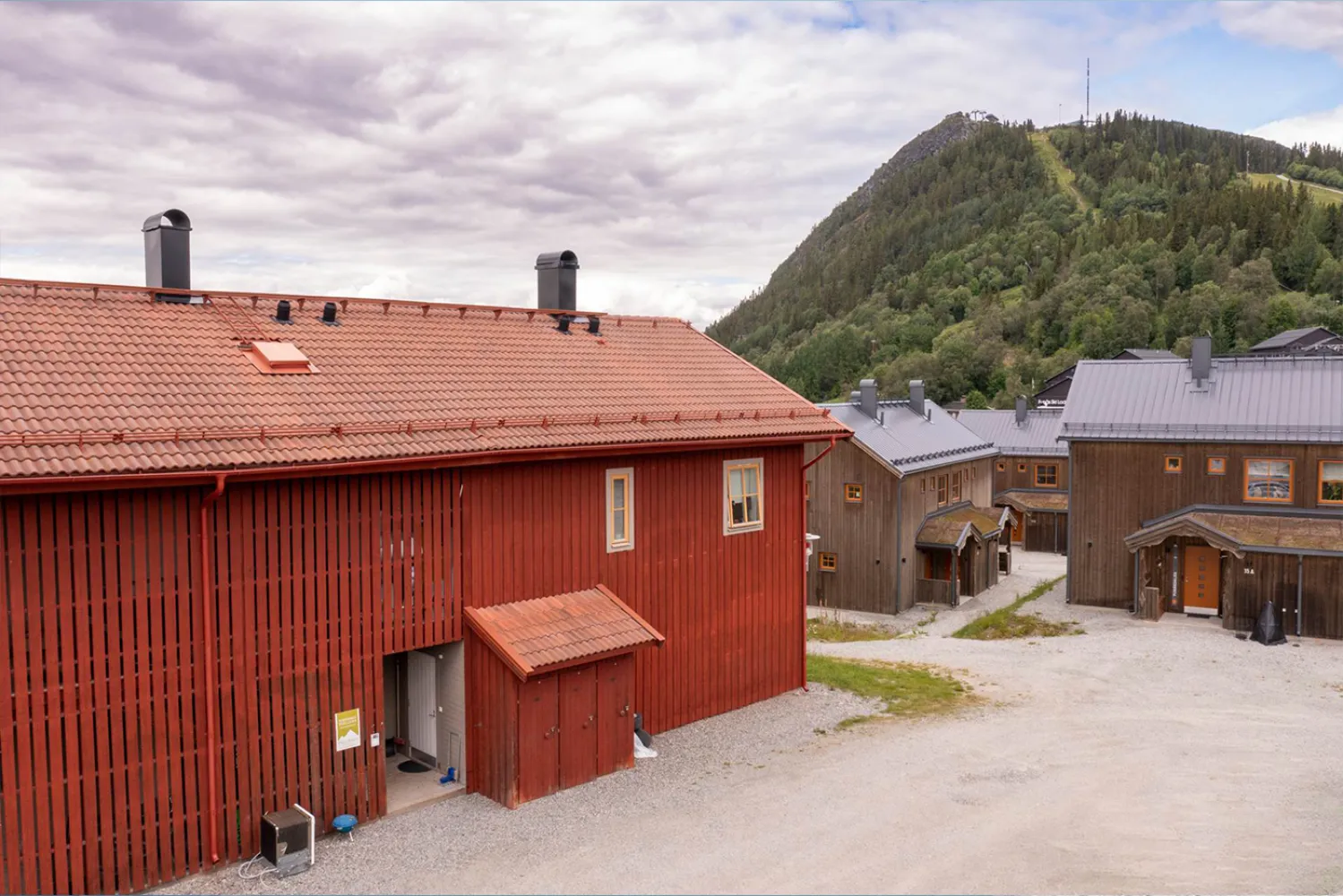 En grupp byggnader med en kulle i bakgrunden