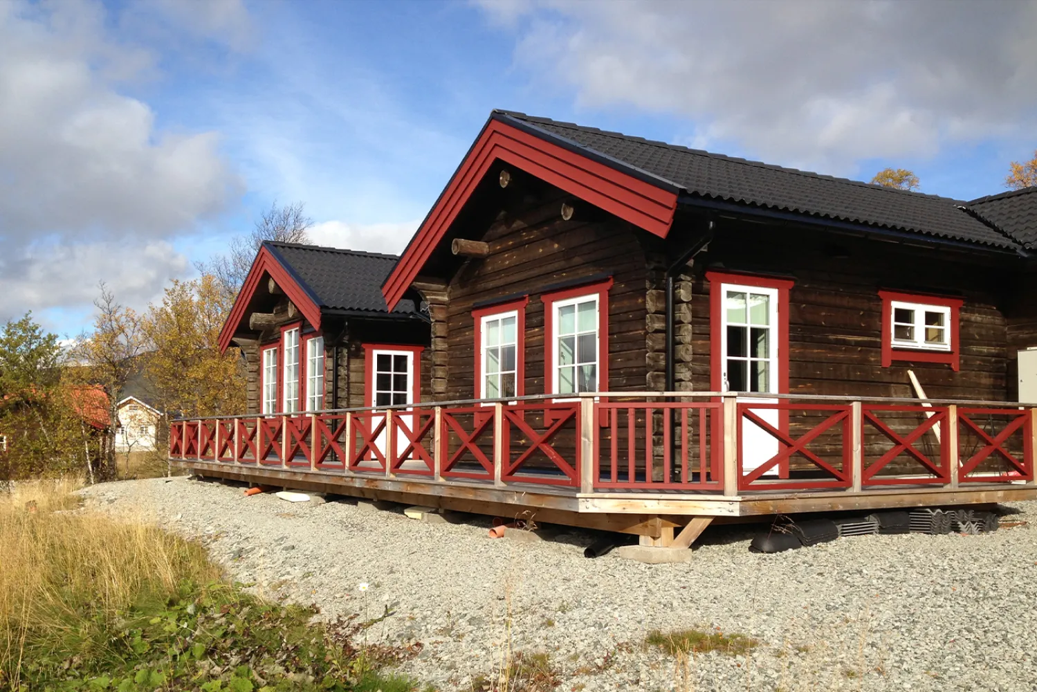 Utsidan av en timmerstuga med röda knutar