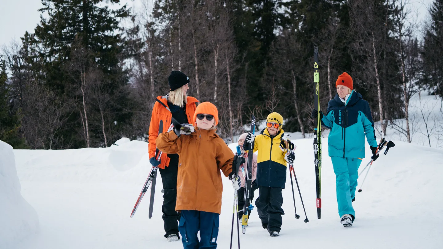 Familj som går med skidor i snön
