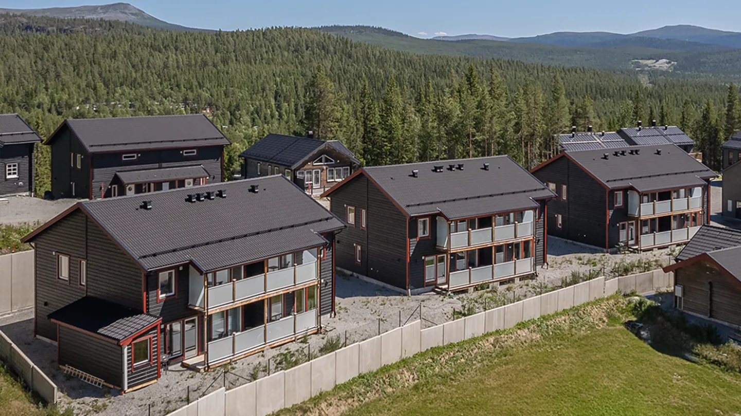 En grupp hus med träd i bakgrunden